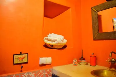 a bathroom with a sink and a basket on the wall at Riad les ANGES DU DESERT in Marrakech