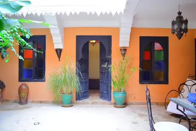 a house with three doors and potted plants at Riad les ANGES DU DESERT in Marrakech
