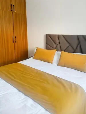 a bed with yellow pillows on it in a room at Appart Cosy in Marrakech