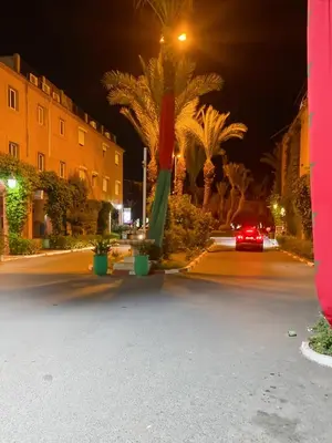 a car is driving down a street at night at Appart Cosy in Marrakech