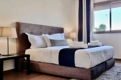 a bedroom with a large bed with a large window at Charming apartment in Agdal in Marrakech
