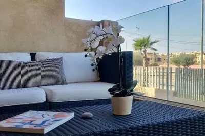 a living room with a white couch and a table at Charming apartment in Agdal in Marrakech