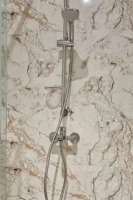 a shower in a bathroom with a marble wall at Charming apartment in Agdal in Marrakech
