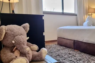 a bedroom with a teddy bear sitting next to a bed at Charming apartment in Agdal in Marrakech