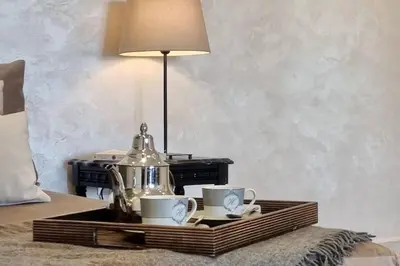 a tray with two cups and a tea kettle on a bed at Charming apartment in Agdal in Marrakech