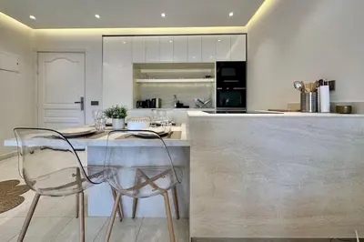 a kitchen with a counter and a bar with chairs at Central Gueliz with Pool and Terrace in Marrakech