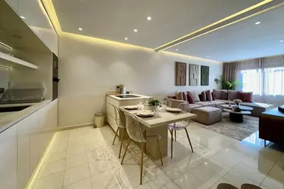 a kitchen and living room with a couch and a table at Central Gueliz with Pool and Terrace in Marrakech