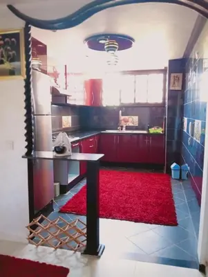 a kitchen with a table and a red rug at Jnan chrifiya in Marrakech