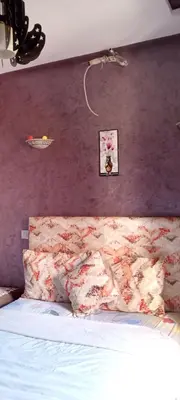 a bedroom with a bed with a purple wall at Jnan chrifiya in Marrakech