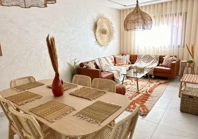 a living room with a table and a couch at Reflet du Désert Appartement bohème à Marrakech in Marrakech