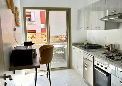 a kitchen with a counter and a table in it at Reflet du Désert Appartement bohème à Marrakech in Marrakech