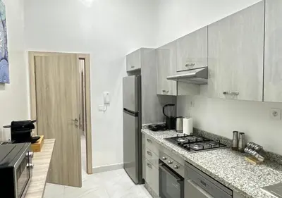 a kitchen with a stove and a refrigerator at Sérénité Berbère Appartement centre Marrakech in Marrakech