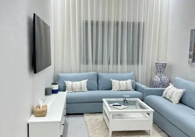 a living room with a blue couch and a table at Sérénité Berbère Appartement centre Marrakech in Marrakech