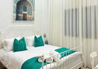 a bedroom with a bed with green and white pillows at Sérénité Berbère Appartement centre Marrakech in Marrakech