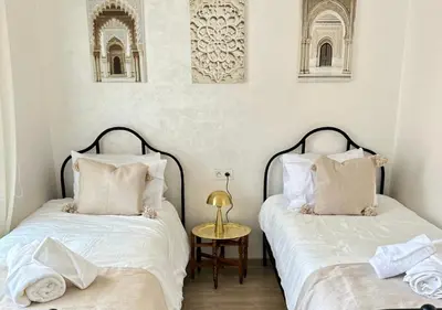 two beds sitting next to each other in a bedroom at Trésor andalous in Marrakech