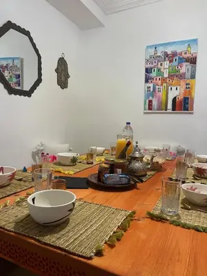 a wooden table with bowls and plates on top of it at Riad Dutilleul in Marrakech