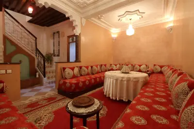 a living room with a red couch and a table at Riad Blue in Marrakech