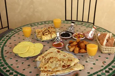 a table with plates of food and glasses of orange juice at Riad Blue in Marrakech