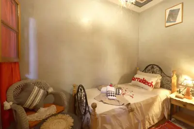 a small bedroom with a bed and a chair at Riad Blue in Marrakech