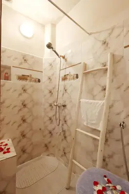 a bathroom with a marble shower with a ladder at Riad Blue in Marrakech