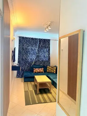 a living room with a blue couch and a table at Appart FAMILY lumineux & terrasse privé in Marrakech