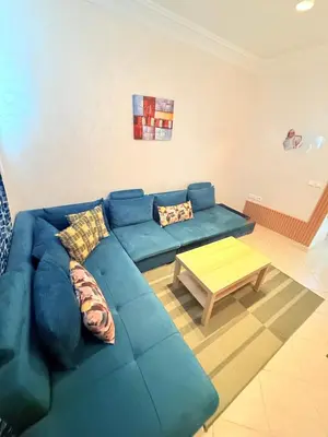 a living room with a blue couch and a coffee table at Appart FAMILY lumineux & terrasse privé in Marrakech