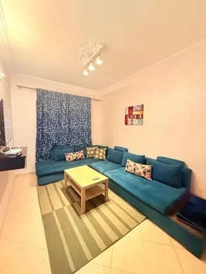 a living room with a blue couch and a table at Appart FAMILY lumineux & terrasse privé in Marrakech