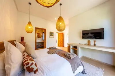 a bedroom with a white bed and pendant lights at Villa Baccarat - Piscine et Luxe in Marrakech