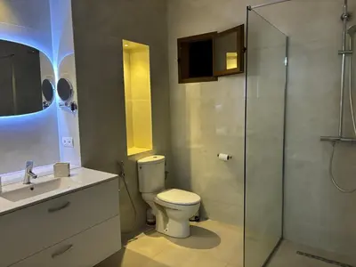 a bathroom with a toilet and a glass shower at Joli appartement à Gueliz in Marrakech