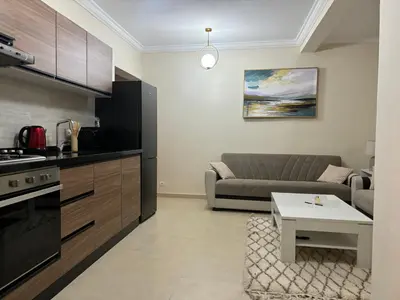 a kitchen and living room with a couch and a table at Joli appartement à Gueliz in Marrakech