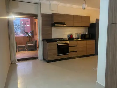 a kitchen with wooden cabinets and a stove at Joli appartement à Gueliz in Marrakech