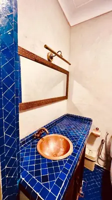 a bathroom with a copper sink on a blue tiled counter at Edwiria Marrakech in Marrakech