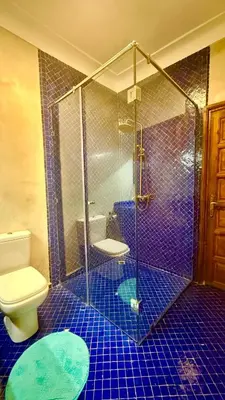 a bathroom with a toilet and a glass shower at Edwiria Marrakech in Marrakech