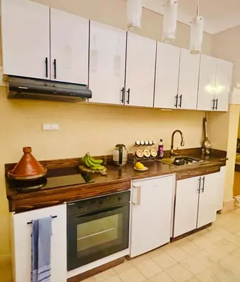 a kitchen with white cabinets and a sink at Edwiria Marrakech in Marrakech