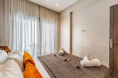 a bedroom with a large window with towels on a bed at Bohochic#appartement#Gueliz in Marrakech