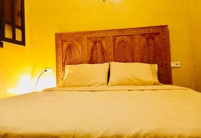 a bedroom with a large bed with a wooden headboard at Dar Rahma- old Town Marrakech in Marrakech