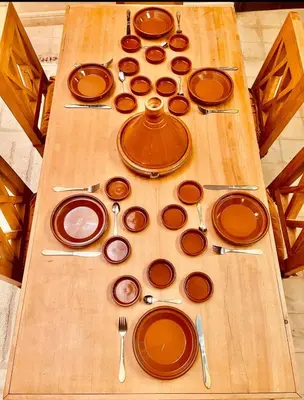 a wooden table with plates and utensils on it at Dar Rahma- old Town Marrakech in Marrakech