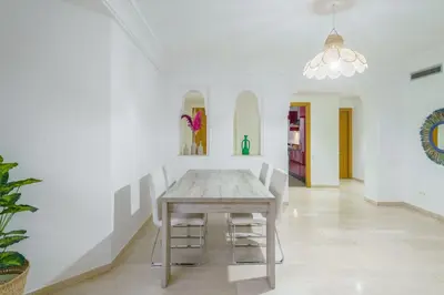 a dining room with a wooden table and chairs at Appartement de charme residence avec piscine WiFi in Marrakech