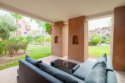 a living room with a couch and a table at Appartement de charme residence avec piscine WiFi in Marrakech