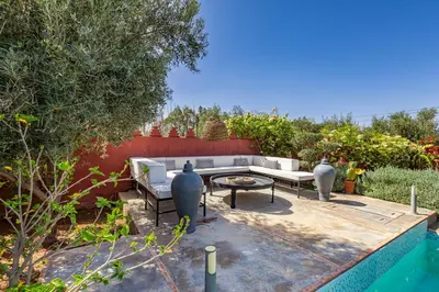 a patio with a couch and a table next to a pool at Private villa Comfort and Relax Pool in Marrakech