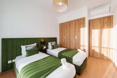 two beds in a room with green and white at Elegance and Serenity at Noria Golf and Pool view in Marrakech