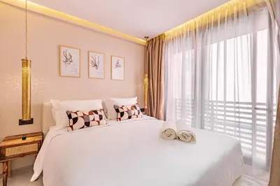 a bedroom with a large white bed with a large window at Duplex Luxury and Comfort in Heart of Gueliz in Marrakech