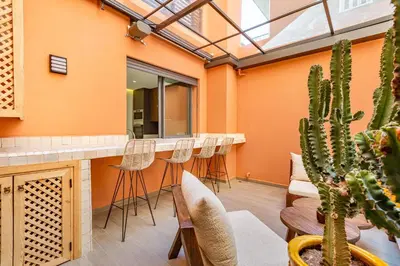 a bar in an orange room with stools and a cactus at Duplex Luxury and Comfort in Heart of Gueliz in Marrakech
