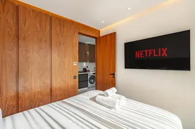 a bedroom with a bed with a television on the wall at elegance et modernite au coeur de la ville in Marrakech