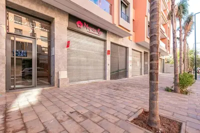 a building with a palm tree in front of a store at elegance et modernite au coeur de la ville in Marrakech