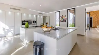 a white kitchen with a bowl of fruit on a counter at VilLA AYDEN in Marrakech