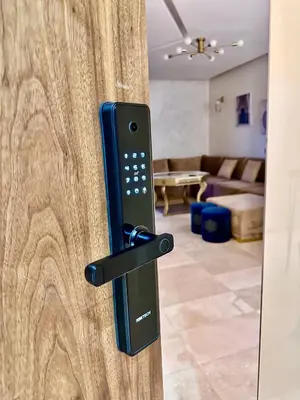 a black door handle on a wooden door with a living room at Pearl Garden Appart 2 chambres Luxe Cosy Moderne in Marrakech