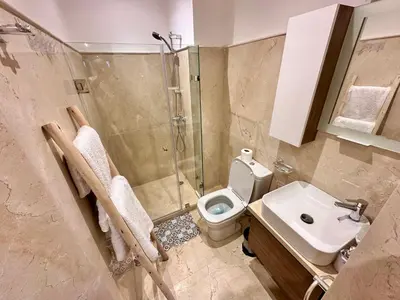 a bathroom with a shower and a toilet and a sink at Pearl Garden Appart 2 chambres Luxe Cosy Moderne in Marrakech