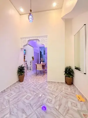 a room with white walls and a marble floor with plants at Appart Cosy Près de laéroport Adapté au Famille in Marrakech