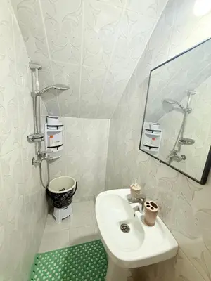 a white bathroom with a sink and a mirror at Appart Cosy Près de laéroport Adapté au Famille in Marrakech
